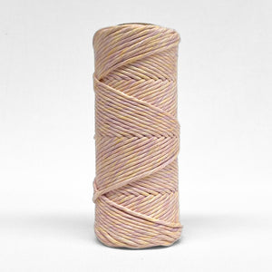 single rolls of pastel lilac and orange standing upright on white background