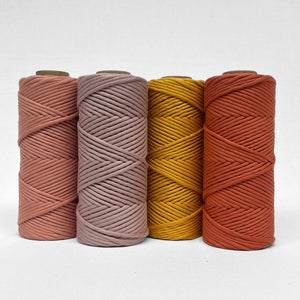 combination image showing four rolls of cotton cord in rosewood smokey lavender marigold and red earth standing upright on white wall showcasing complimenting colours