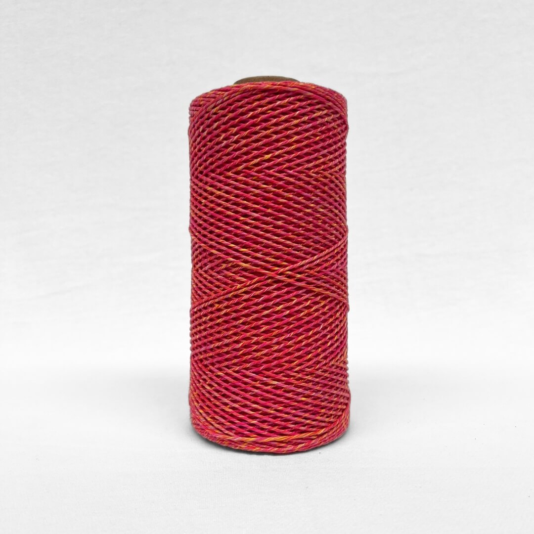 image of a single roll of 1.5mm mixed macrame string warp in sunburst colour way standing upright on white background 
