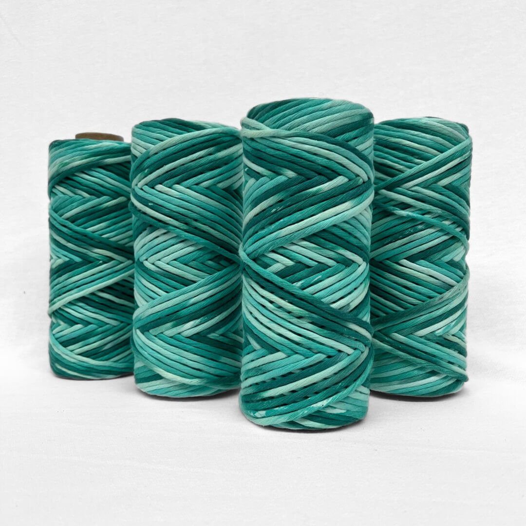 four rplls of hand painted 4m string in blue and green colour on white background