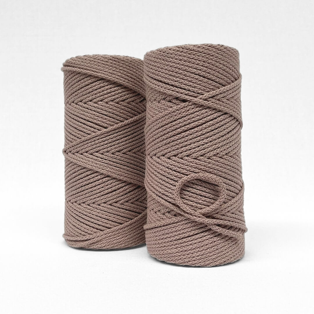 two rolls of quartz brown braided cord showing up close detailed of woven string in white background