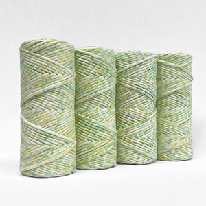 four rolls of lime splice watercolour macrame string standing upright on white background 