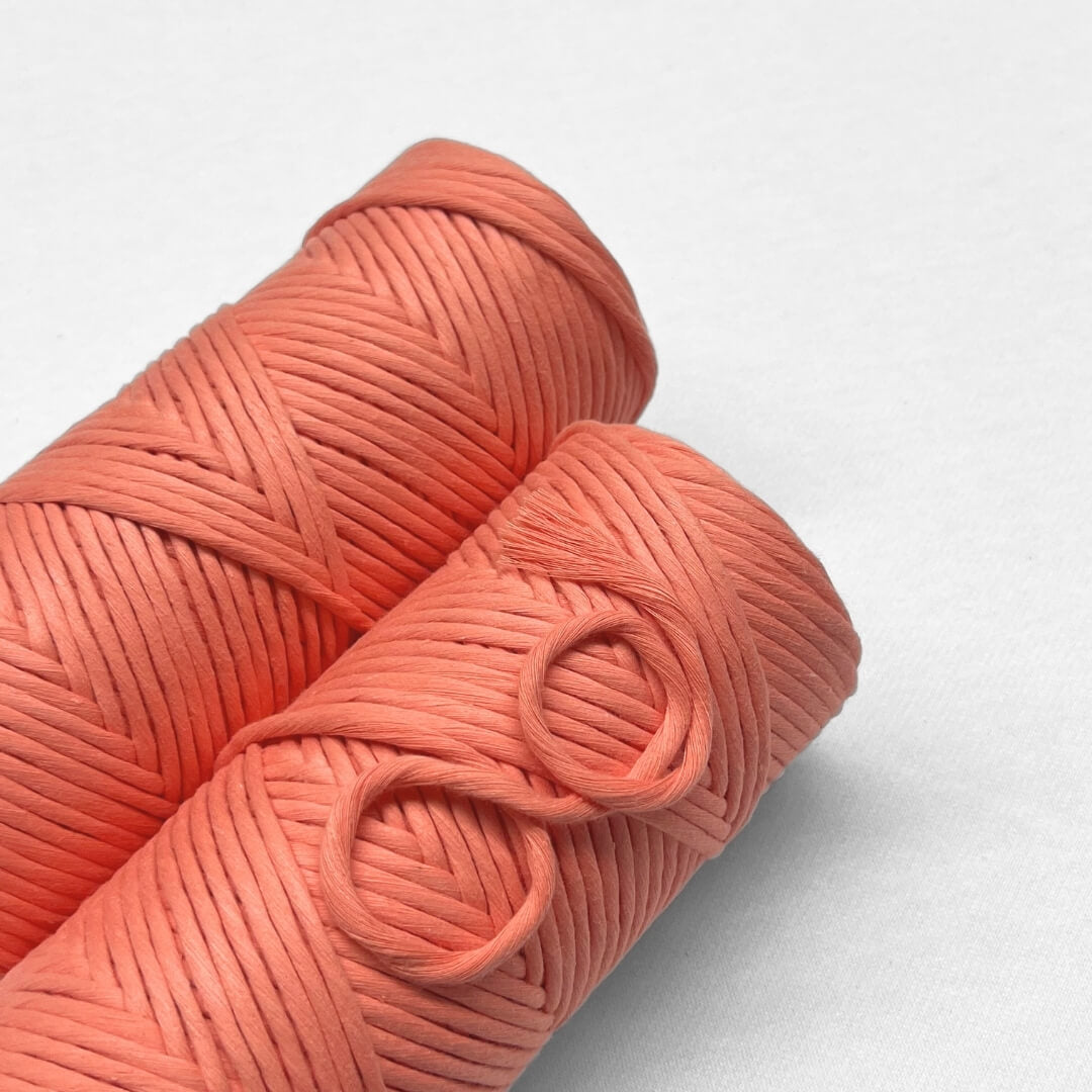 two rolls of coral crush cotton cord on white background