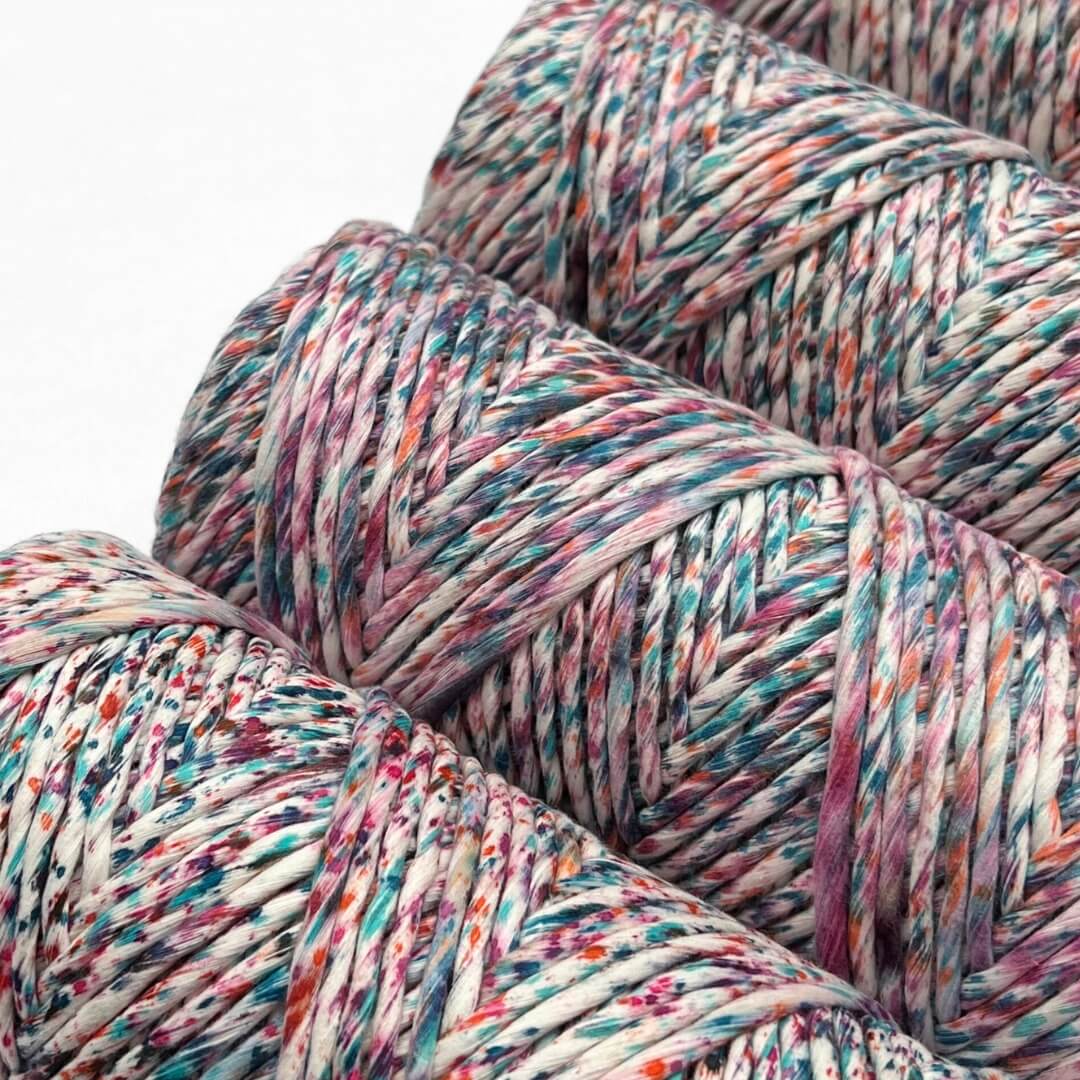 zoomed in image of cloud 9 speckled cord in rainbow harlequin colour way laying flat with white background highlighting the vibrant colours in product