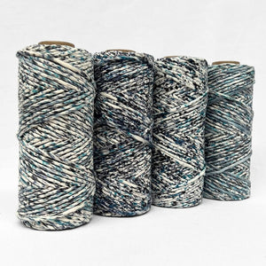 deep blue and black hand dyed confetti cord for macrame and diy crafts on white background