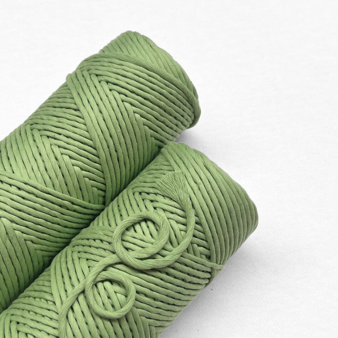 two rolls lemongrass green macrame cord laying flat on white background