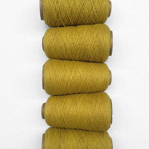 Chartreuse yellow thin wool yarn laying vertically from top to bottom on white background