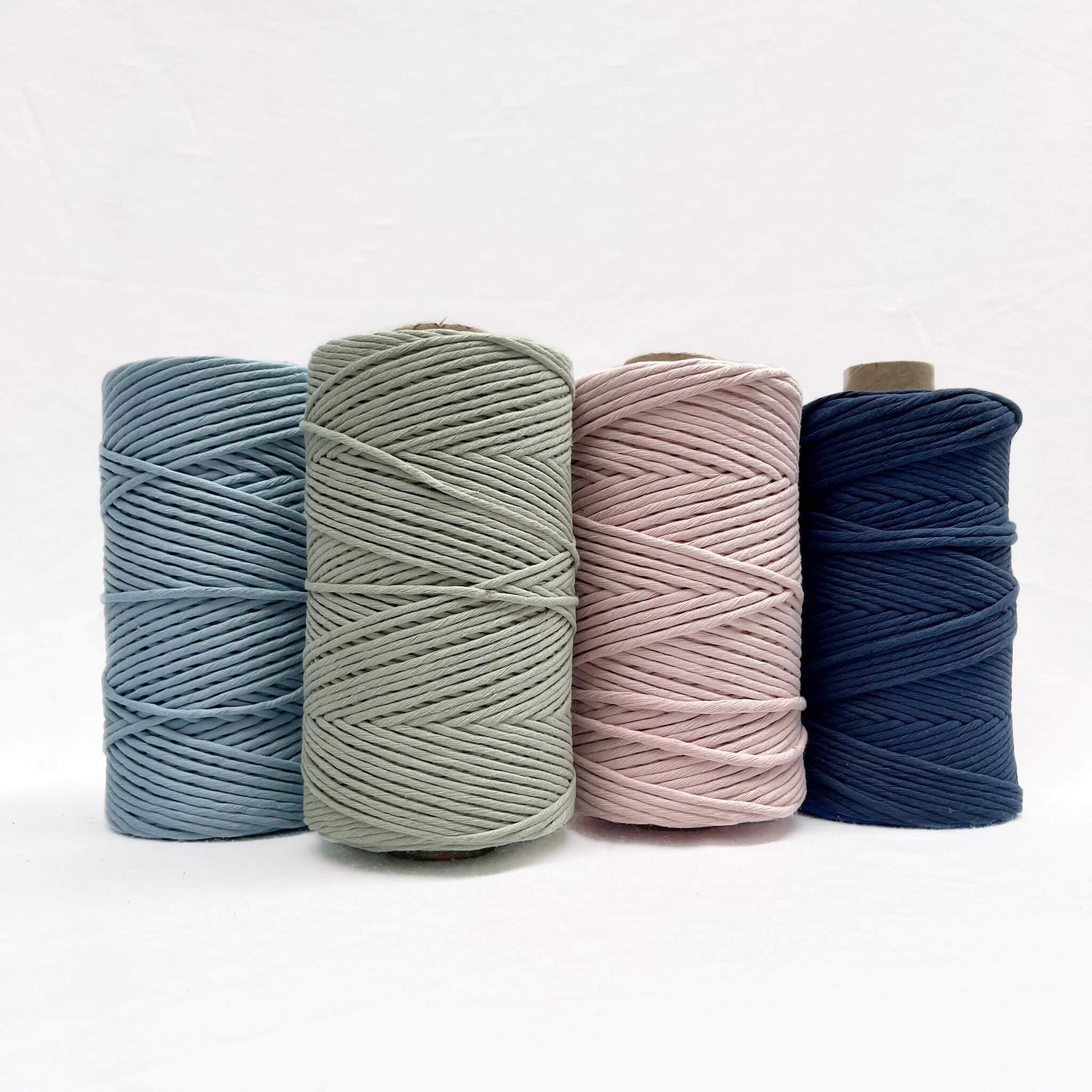 powder baby blue sage green light pink navy blue cotton cord for macrame in group photo four rolls standing up on white background