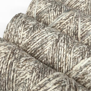 neutral brown and grey confetti cottons string close up for weaving and macrame on white back drop