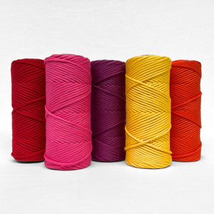 five rolls of macrame cord in combination photo showing complementing colours ladybug red hot pink rich orchid daffodil yellow and flame orange standing side by side on white background