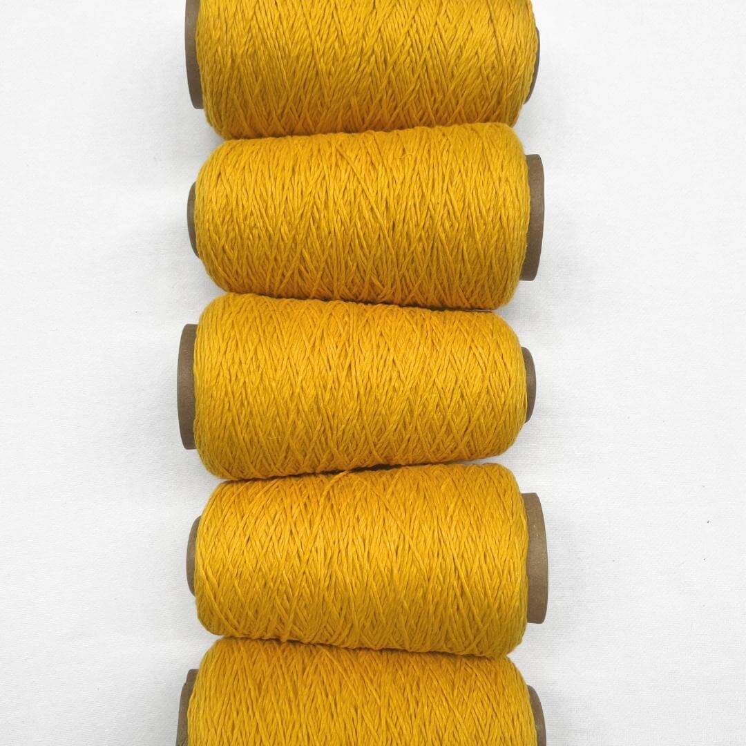Bright sunflower yellow wool cord five rolls laying side by side from top tp bottom of photo on white background