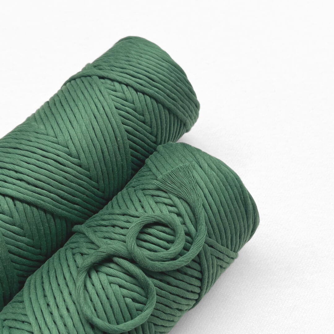 two roll of evergreen macrame cord laying down on white background