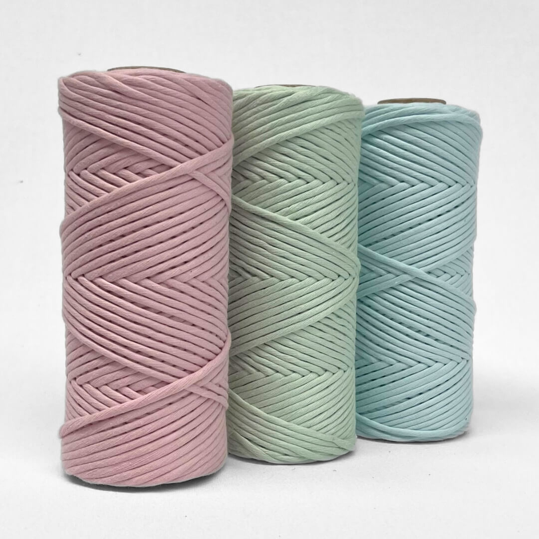 three rolls of 4mm string in pink mint and blue frost stading upright on white background showing complementing colour palette 