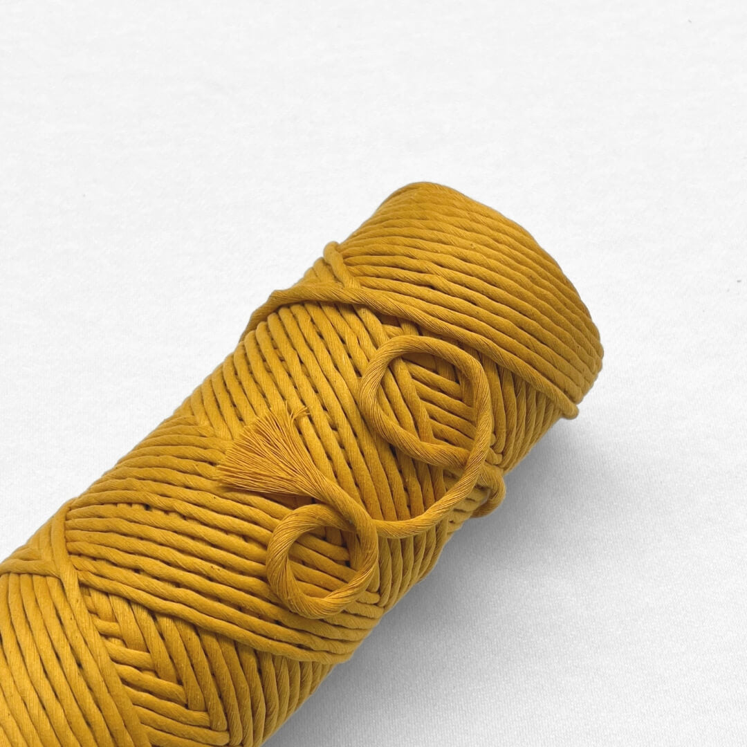 7a marigold yellow macrame cord laying down on angle with white background