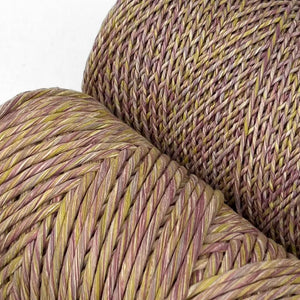 close up image of the 1.5mm and 4mm mauve marigold purple yellow mixed cotton string for macrame and weaving lying down on white background