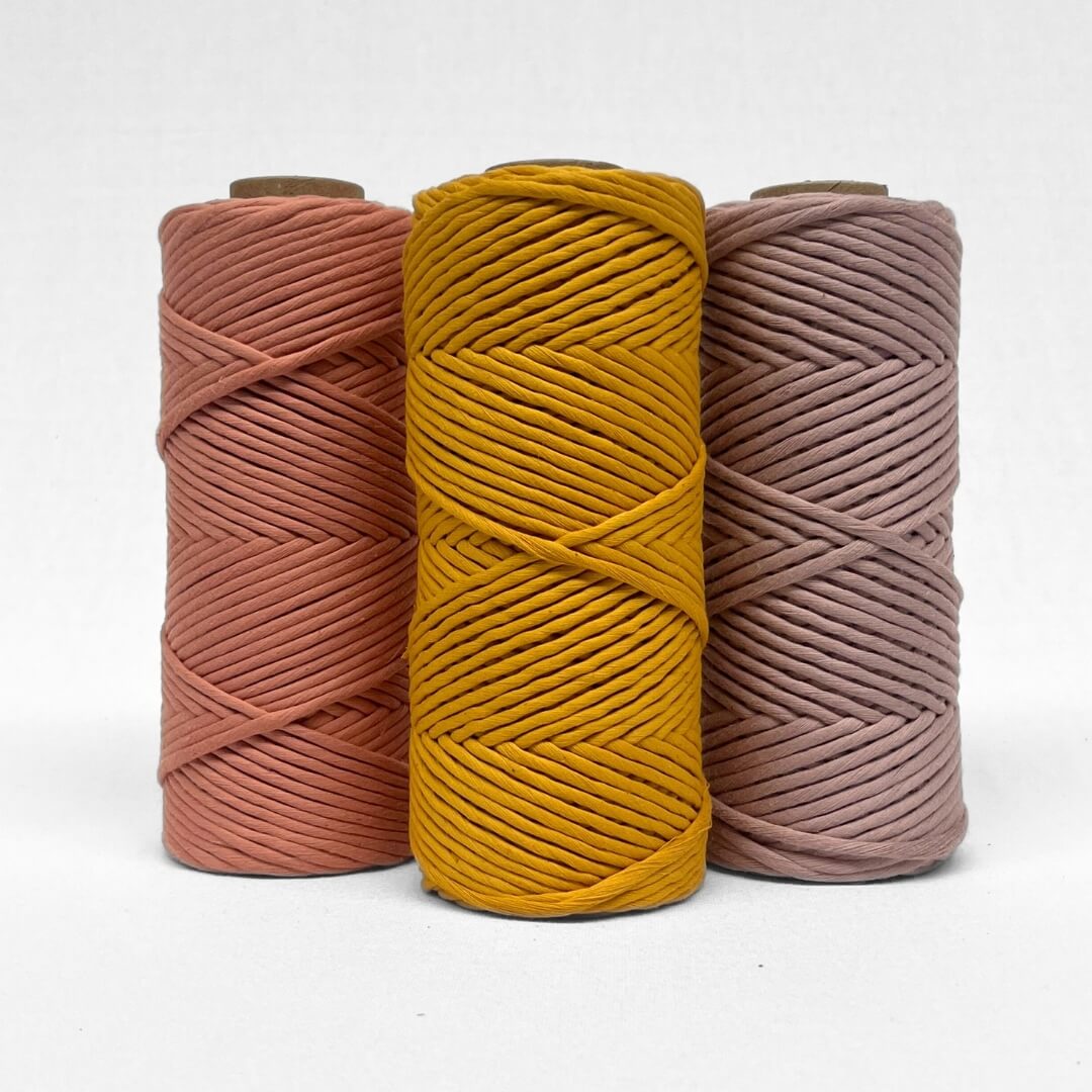 7c three rolls of macrame cord in marigold smokey lavender and rose wood staining straight up on white background 