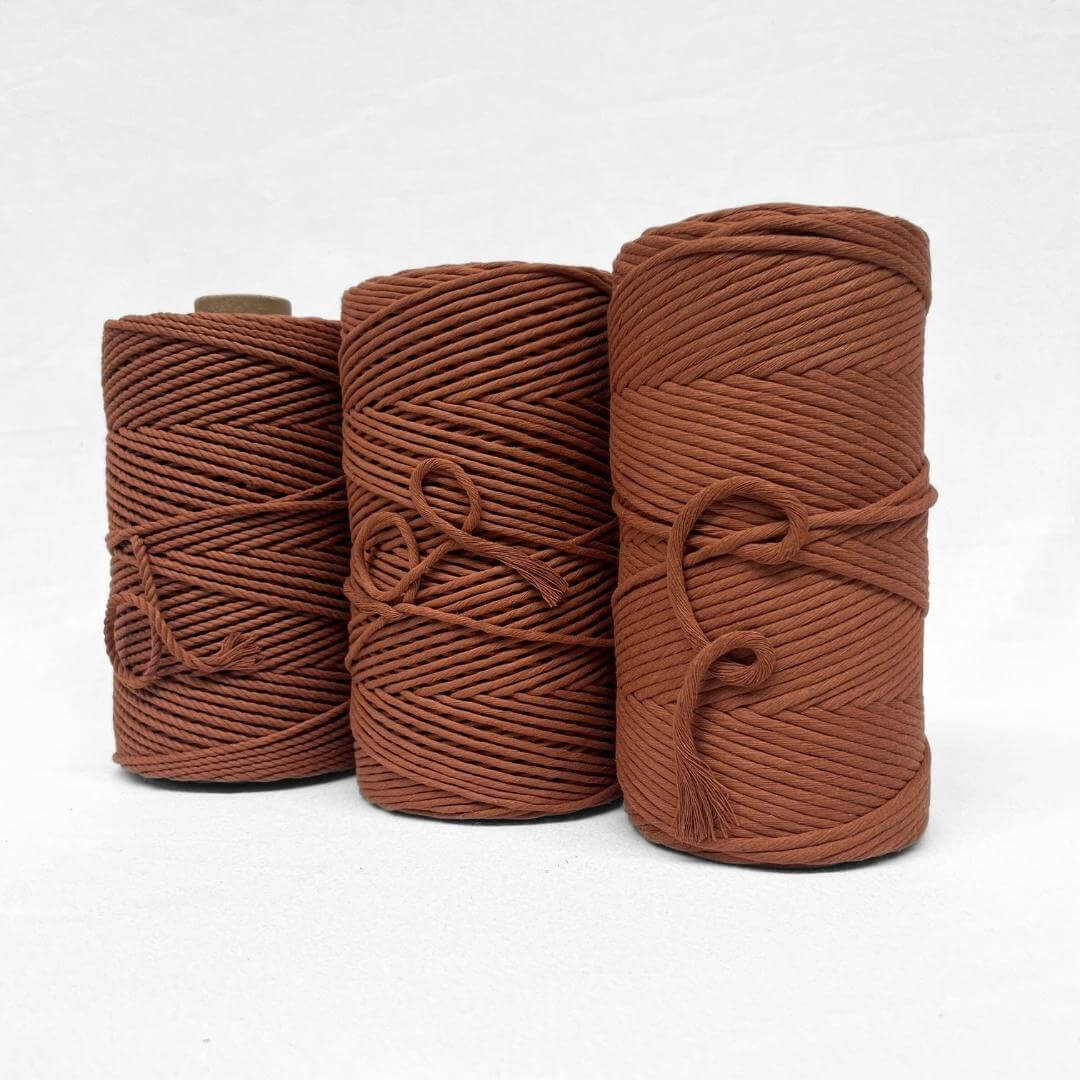 one roll of warm brown coloured cotton rope roll close up image showing texture and softness on white background 
