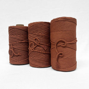 image of three rolls of warm brown cotton cord showcasing 3mm string 5mm string and 4mm rope variations on white back drop 