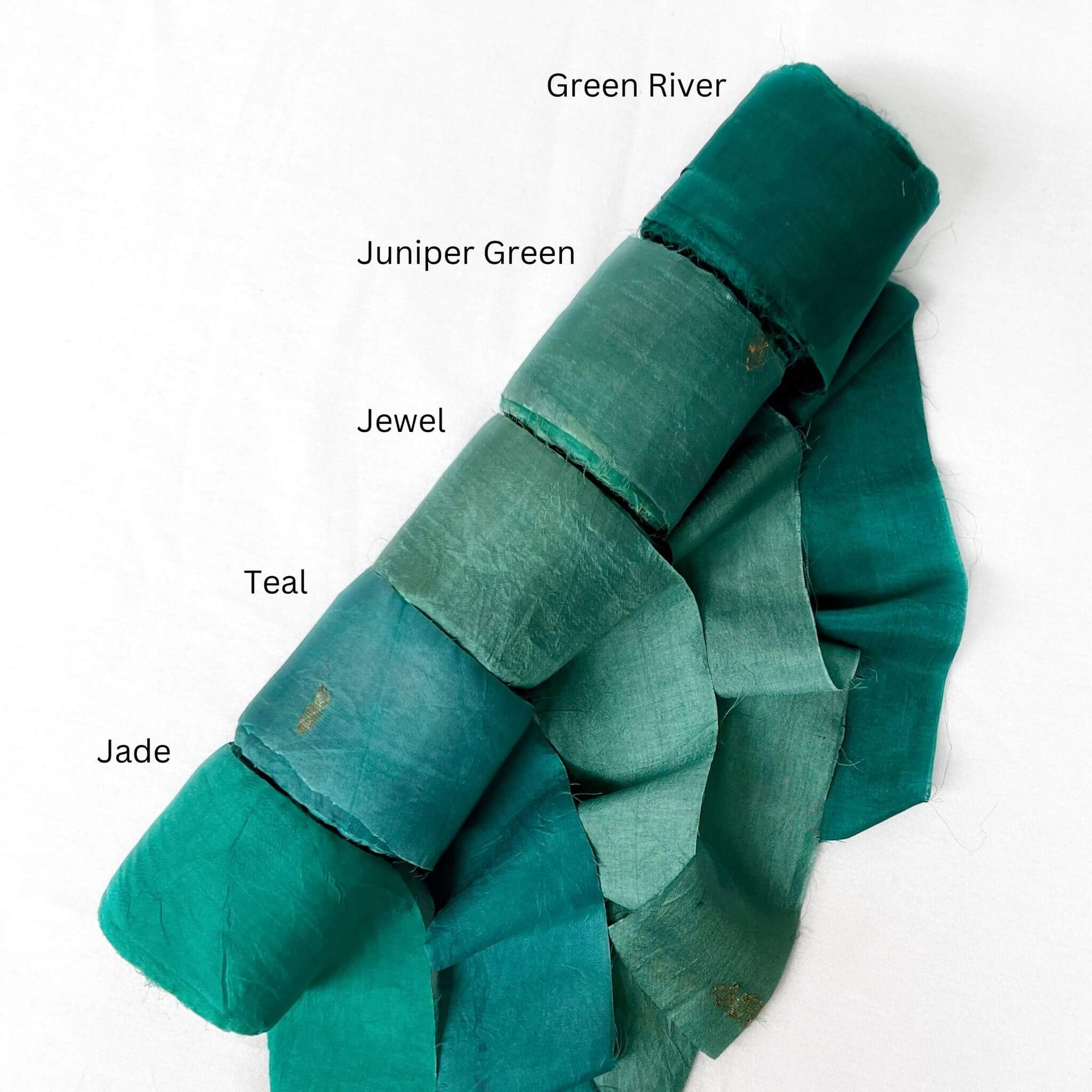 moody green colours river juniper jewel teal jade green wide silk ribbon on white background showing softness