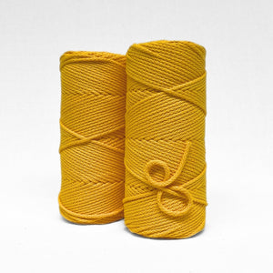 two rolls on bright sunflower yellow cotton braided 4m cord on on white wall