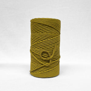 5mm cotton string roll in chartreuse yellow standing alone on white wall