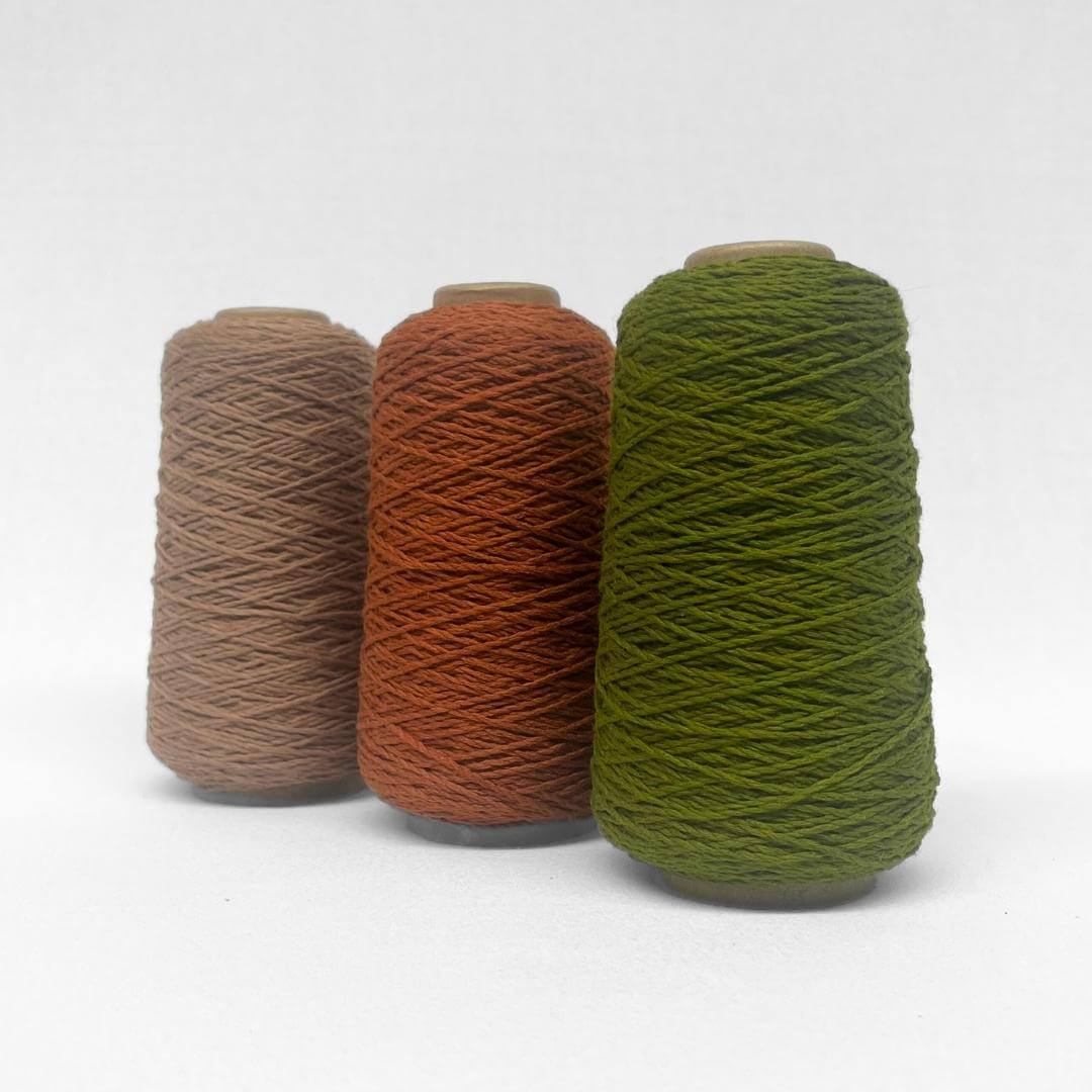 combination image sowing three rolls of thin wool yarn in olive rust and brown colour-way standing side by side on white background 