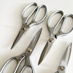 metal scissors in group photo on white wall