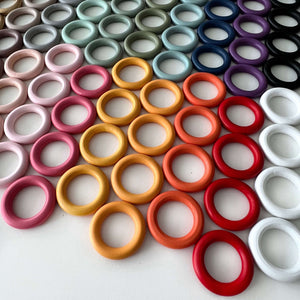 rainbow coloured wooden 55cm wooden rings for craft laying on desk