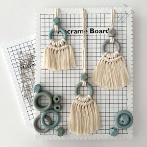 macrame pin board with small wall hanging on top to show scale and function
