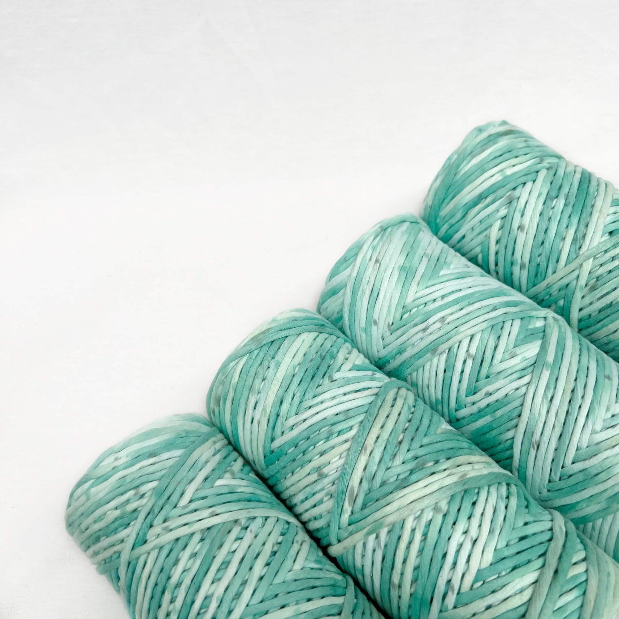 mint green macrame cord laying against white background to show quality and texture