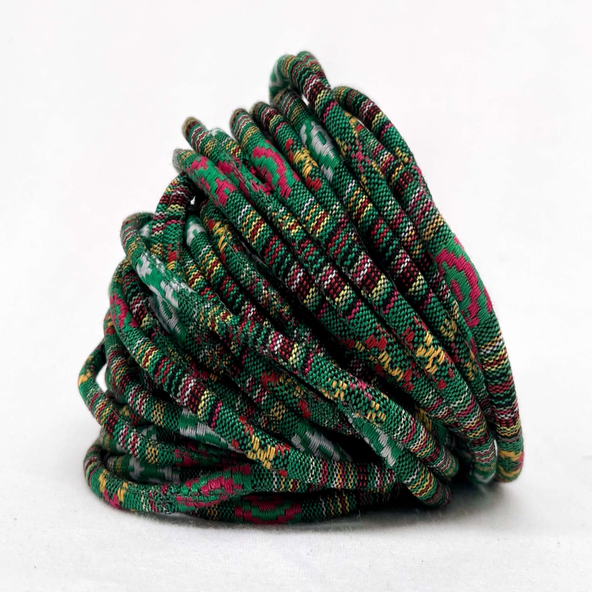 green and red braided woven cord against white background